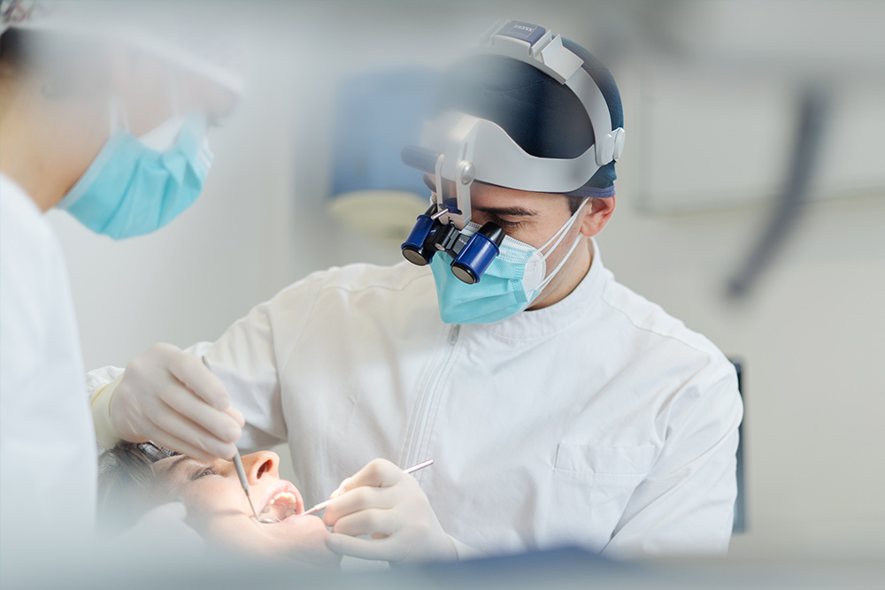 Due professionisti dello Studio Medico Dentistico Santa Apollonia intenti a recuperare un dente da carie